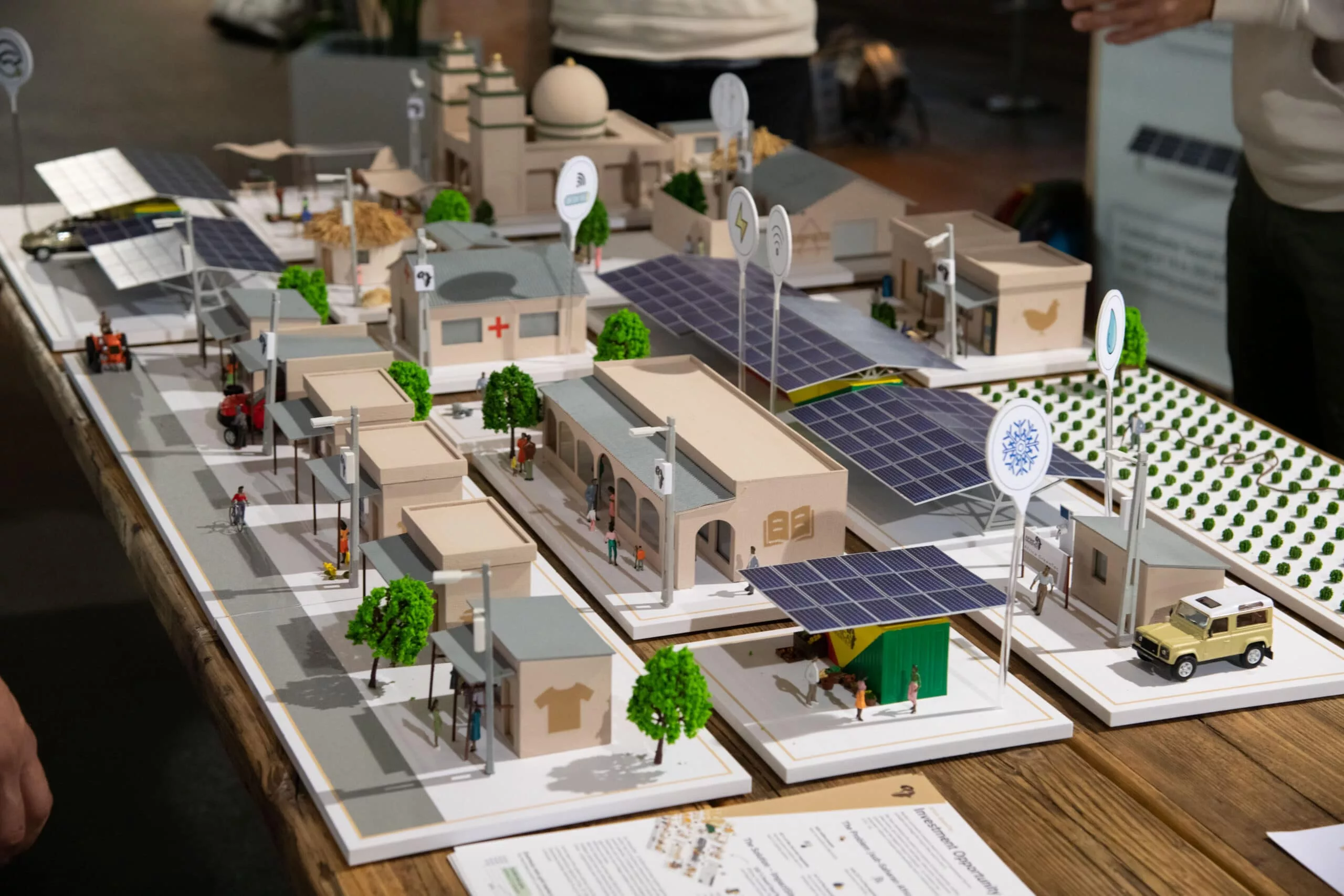 Modell von einer Gebäudeanlage mit Nachhaltigkeitsaspekten wie Bäumen, Solar etc.