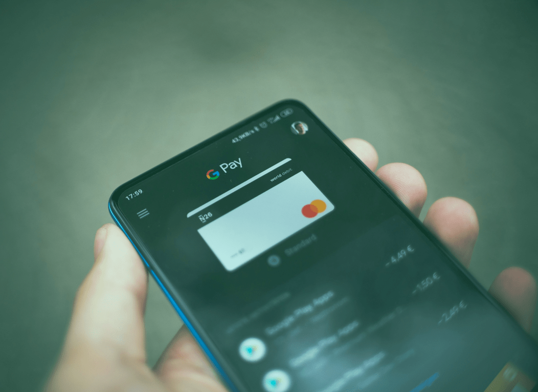 Hand hält ein Smartphone, auf dem eine Bankanwendung zu sehen ist