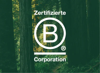 B Corp logo in front of trees